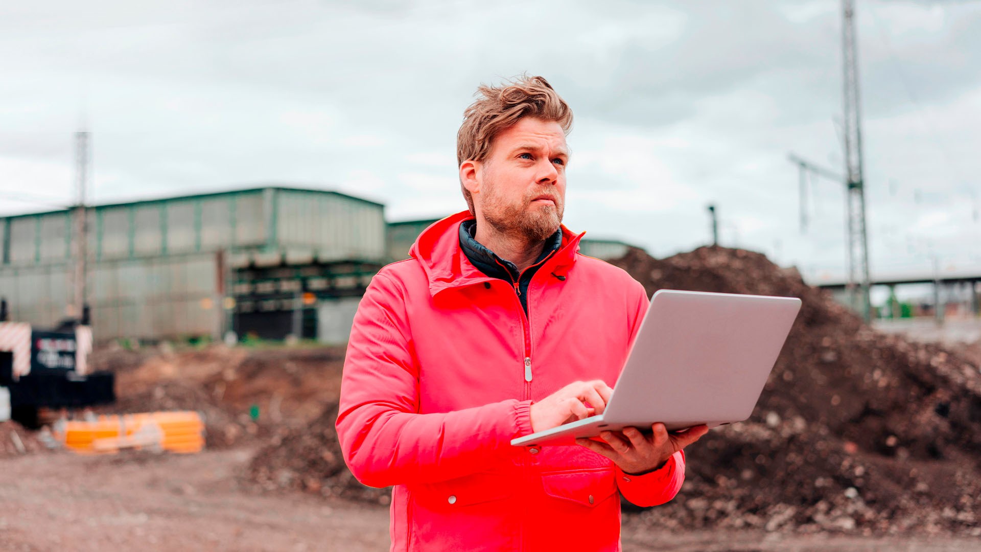 Un homme utilise un ordinateur portable sur un chantier pour accéder à l'Espace Client afin de louer des outils pour la construction